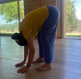 a man in a yellow shirt is bending over his head, bend over, classe di bioenergetica