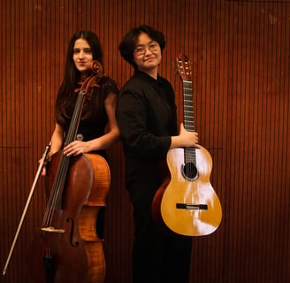 two women holding a guitar and a cello