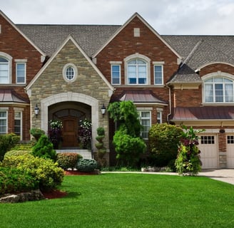 Stately red and tan brick house with lush landscaping in Tennessee 