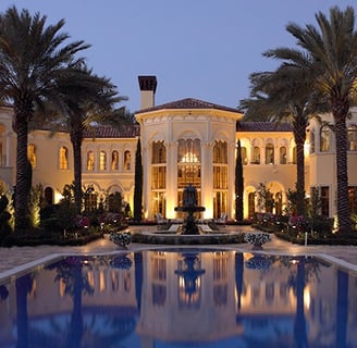 Grand elegant mansion in Florida with a swimming pool and palm trees in the evening