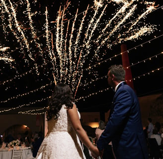 Golden fireworks bursting as the couple makes their unforgettable wedding entrance.