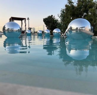 Elegant silver balloons floating beautifully above a luxurious poolside wedding in Santorini