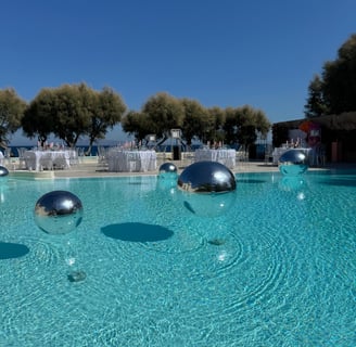 Mirror silver balls reflecting the scenic beauty of a Santorini wedding venue.