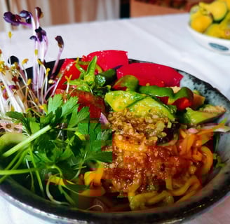 a bowl of food with a salad on a table