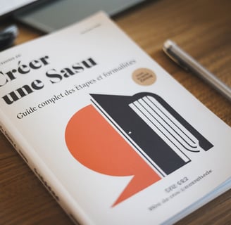 a book with a pen and a pen on a table LEGALIS Cabinet de Conseil