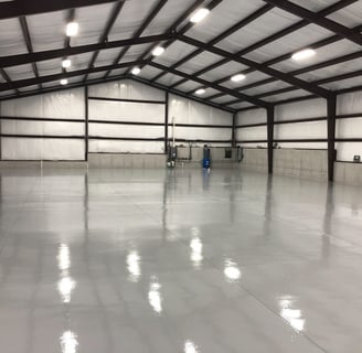 a large warehouse style building with a large metal roof epoksi zemin kaplama