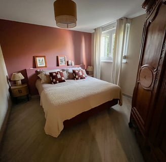 a bedroom with a bed and a wooden cabinet