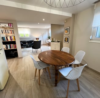 a dining room table with chairs and a refrigerator