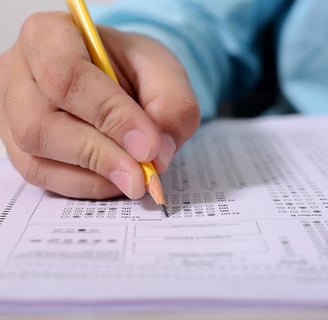 student filling in answers on a scantron during an ACT test after preparing with Benny DePoyster