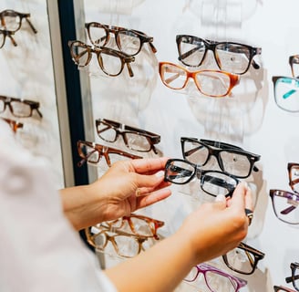 photo de mains opticien qui prend une paire de lunettes en main