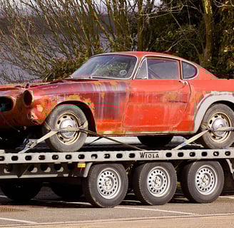 a car is being towed down a flatbed trailer