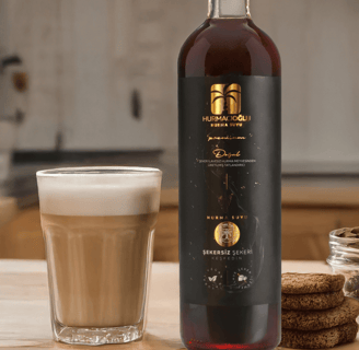 a bottle of coffee in a glass with a glass of hurmacioglu hurma suyu