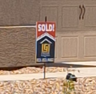 a sold sign in front of a garage door