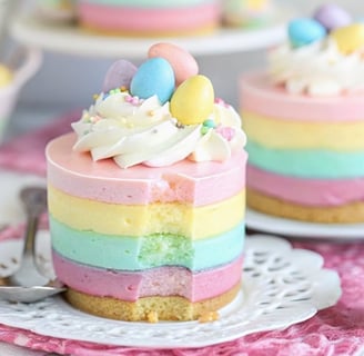 a rainbow layered cheesecake - colored cheesecake on a plate