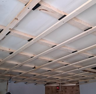 Grid-style ceiling framing structure prepared for wood panel installation during interior levelled renovation project