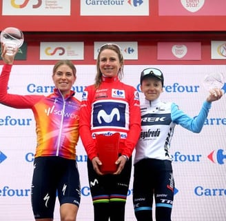 a woman standing on a podium with two other women