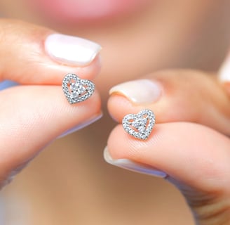 a woman's hand holding a pair of diamond earrings