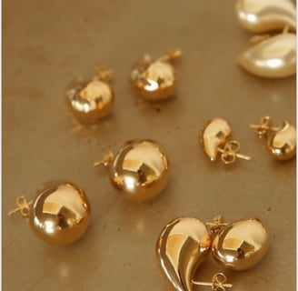 a bunch of gold earrings and earrings