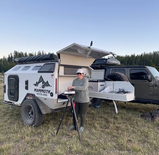 Emily sparks up a meal next to the Mammoth Overland HV