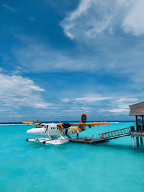 a seaplane with a woman sitting on a dock