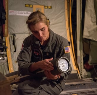 U.S. Naval Academy Midshipman First Class Julia Von Fecht aboard a WC-130J Super Hercules readies an AXBT. USAF photo
