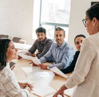 a woman talking to a table full of colleagues