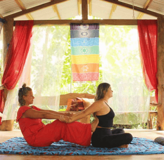 two women in red dresses are sitting on a mat