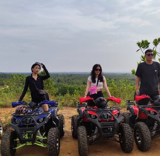 a group of people standing around four wheeler quad atvs