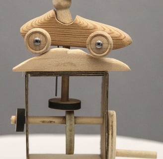 Simple automaton featuring a small wooden racing car and driver