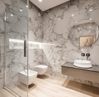 Baño moderno reformado en Valencia con acabados elegantes y grifería eficiente.
