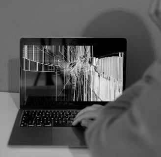Frustrated person at computer with broken device display, needing expert troubleshooting help