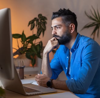 a man sitting at a desk with a laptop computer