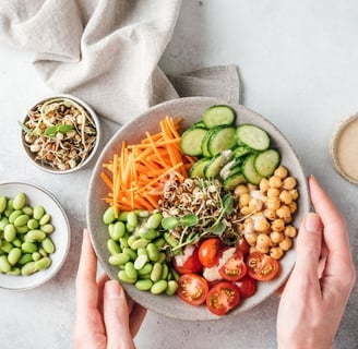 a person holding a bowl of food with vegetables