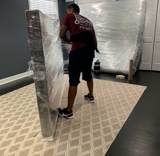 a man is protecting  a mattress with shrinkwrap. like a professional mover