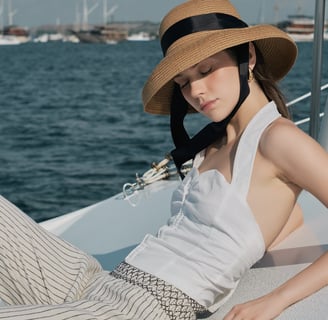 Woman in a hat on a boat wearing LOULOU, photographed by Bali fashion photographer Theodorous Yuvens