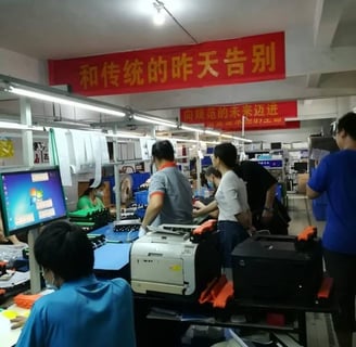 a group of people standing around a computer desk