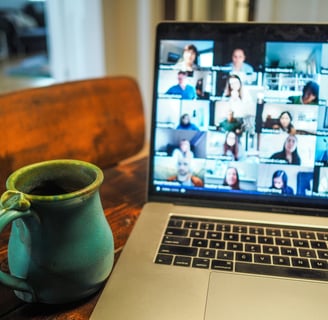 a laptop computer with a cup of coffee and a mug of coffee