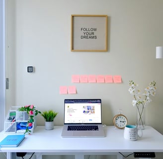 a laptop computer sitting on a desk with a note pad attached to it