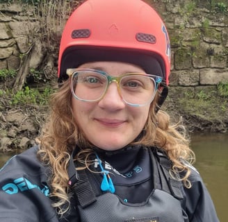 selfy of the owner of Let's Paddle wearing paddling gear, a helmet & Bouyancy Aid on a paddleboard.