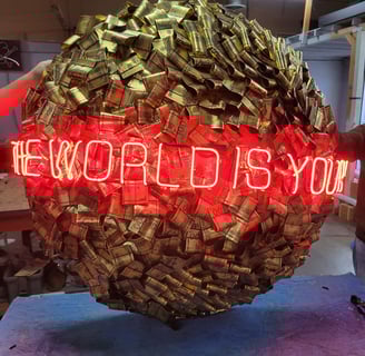 a large red neon sign that says the world is yours
