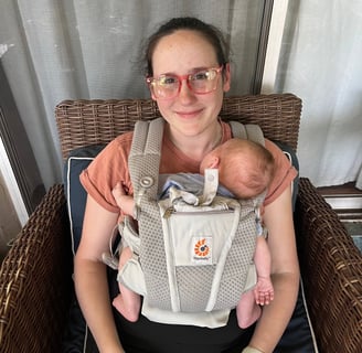 Mom wearing her newborn in an Ergo baby carrier.