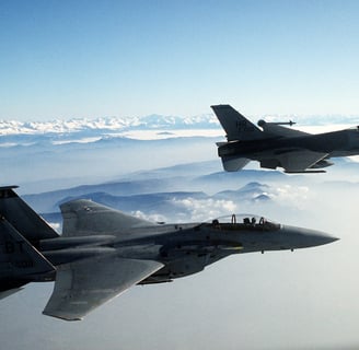 two jets are flying in the sky above the clouds