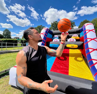 a man holding a basketball ball and a basketball inflatable court