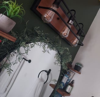 a bathroom with a mirror and a plant in the middle