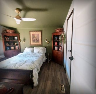 a bedroom with a bed and a wooden floor