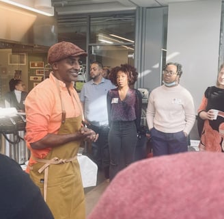 a group of people standing around a table with chef marcus samuelsson