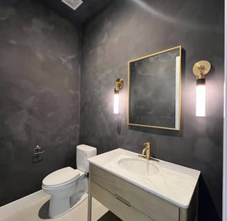 Modern black limewash bathroom with a textured matte finish, featuring elegant contrast and a moody,