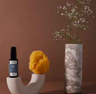 a vase with a flower in it and a bottle of essential oils