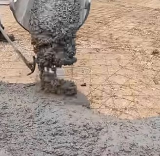 Concrete being poured into a driveway that has rebar positioned already which provide stability.