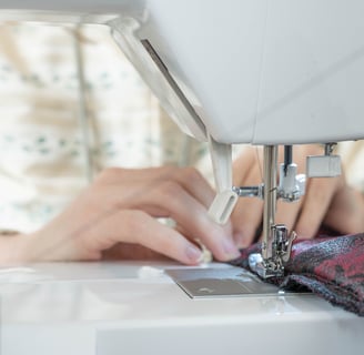 Mains guidant le tissu sur une machine à coudre